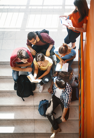 students sitting on stairs in a school